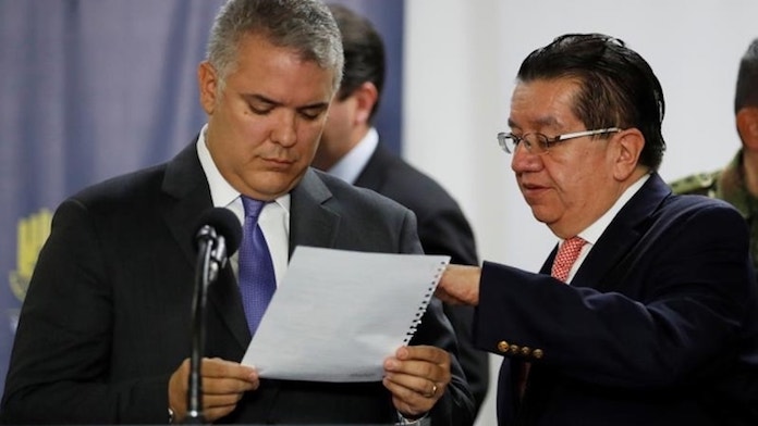 El presidente de Colombia, Iván Duque (i), lee una hoja de papel junto al ministro de Salud colombiano, Fernando Ruíz (d), antes de dirigirse a los medios en una rueda de prensa este jueves, en Bogotá (Colombia). EFE/ Carlos Ortega/Archivo