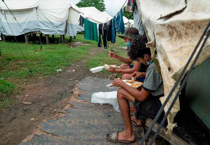 "Te advierten no ir pero la necesidad está", hablan los migrantes del Darién - migrantes mientras comen en un centro de recepción